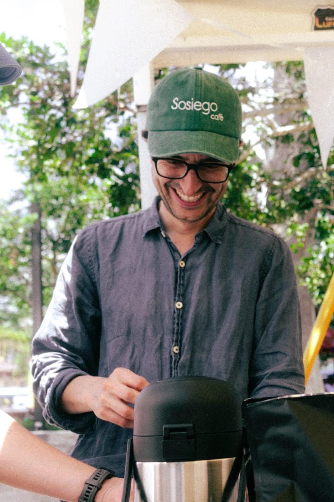 A member of the Sosiego team laughs while making coffee